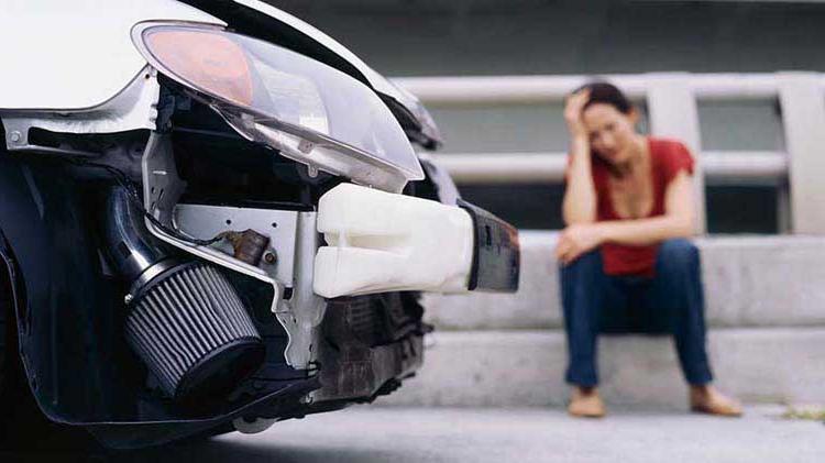 Upset woman near her car after an accident